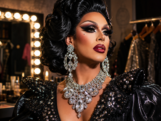 Drag Queen im Backstage-Spiegel mit funkelnden Ohrringen, Halskette, Armbändern und Bühnenaccessoires.